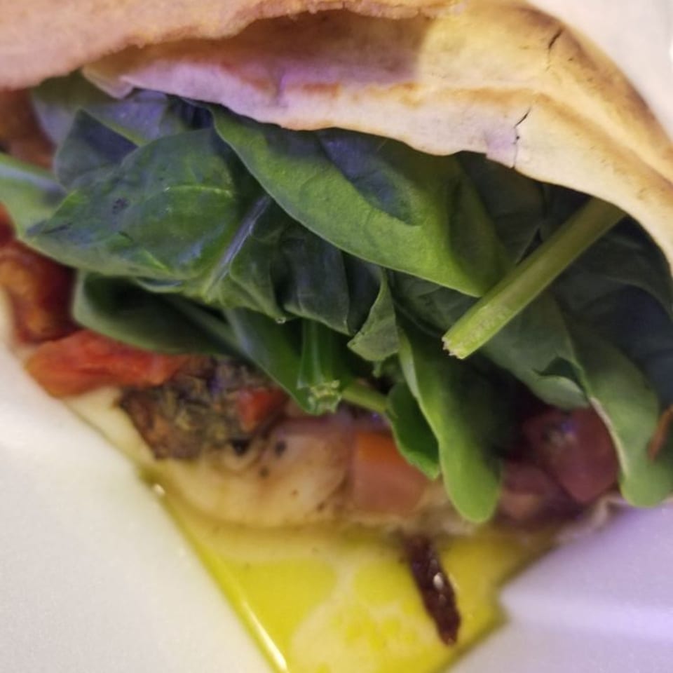 Savory crepe from Crepes Café, filled with fresh spinach, tomatoes, and melted cheese.