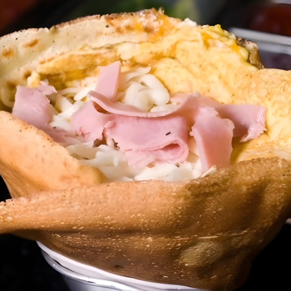 Savory crepe from Crepes Café, filled with ham, melted cheese, and scrambled eggs.