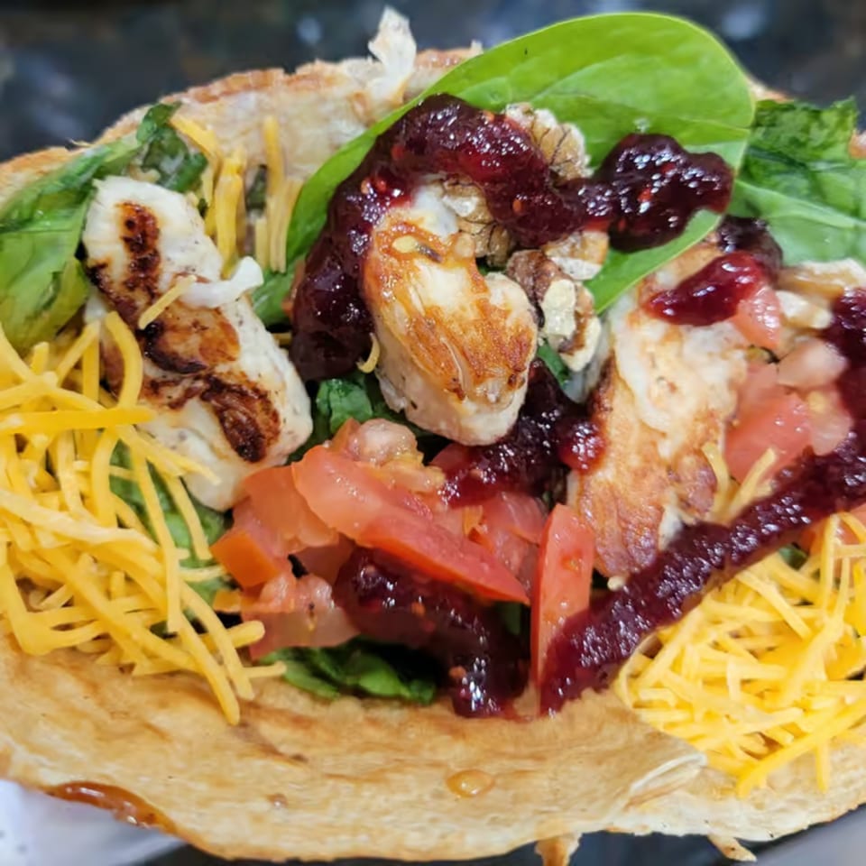 Savory Crepes Café crepe with grilled chicken, cheese, spinach, tomatoes, walnuts, and berry sauce.